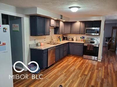 kitchen featuring wood finished floors, light countertops, appliances with stainless steel finishes, and a sink