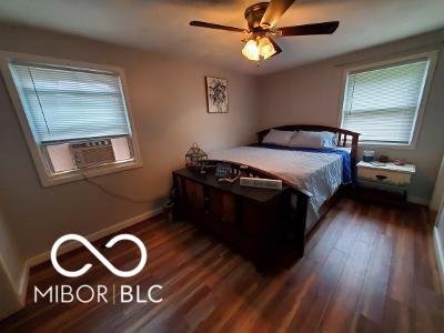 bedroom featuring ceiling fan, cooling unit, wood finished floors, and baseboards