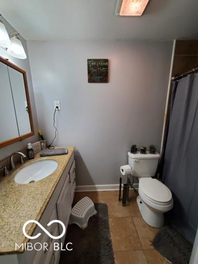 bathroom with baseboards, toilet, a shower with curtain, tile patterned floors, and vanity