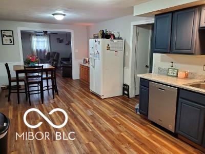 kitchen featuring white refrigerator with ice dispenser, a sink, wood finished floors, light countertops, and dishwasher