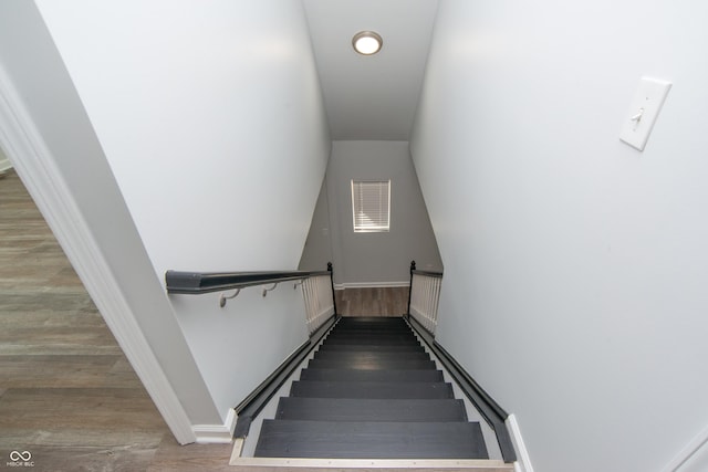 stairway with baseboards and wood finished floors