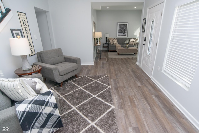 living area with baseboards and wood finished floors