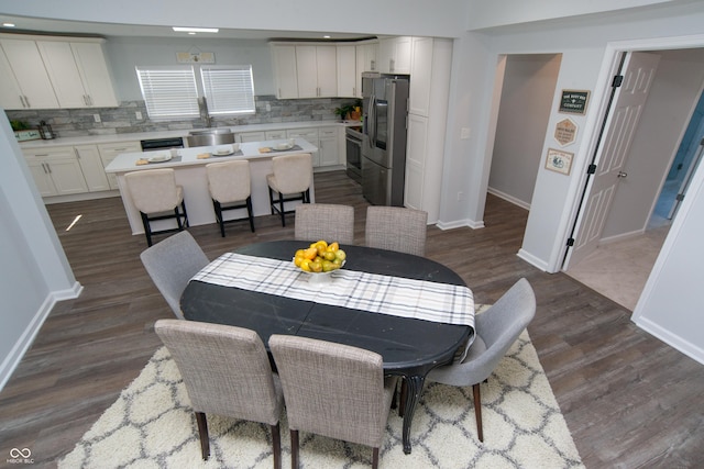 dining area featuring dark wood-type flooring and baseboards