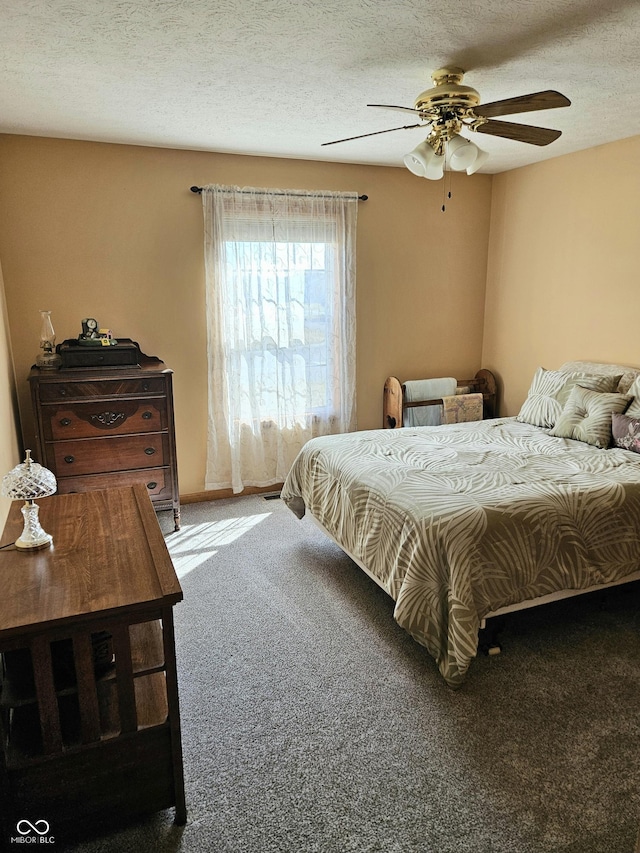 carpeted bedroom with a textured ceiling and a ceiling fan