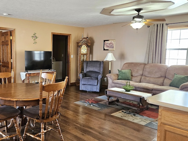 living area with a ceiling fan, dark wood finished floors, and a textured ceiling