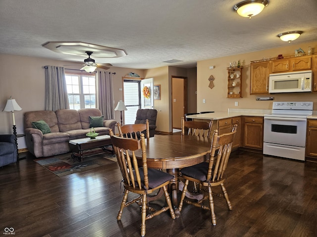 dining space featuring dark wood-style floors, a ceiling fan, visible vents, and a textured ceiling