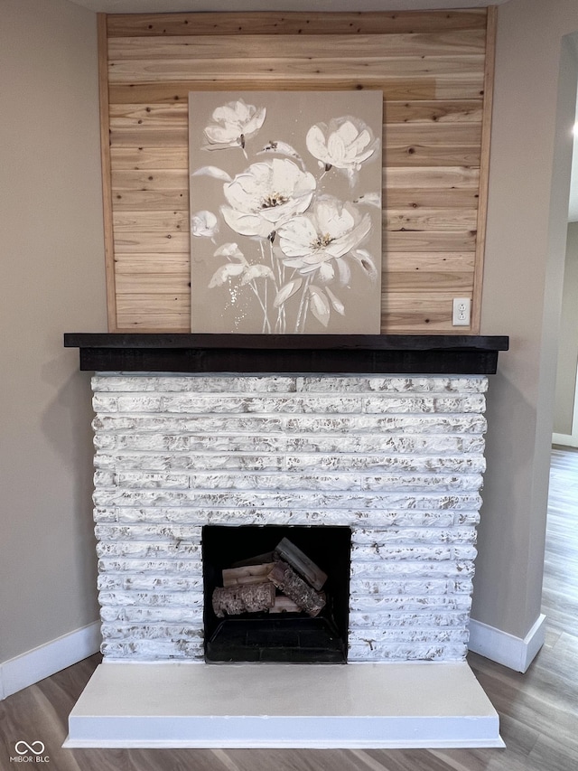 interior details with a fireplace, baseboards, and wood finished floors