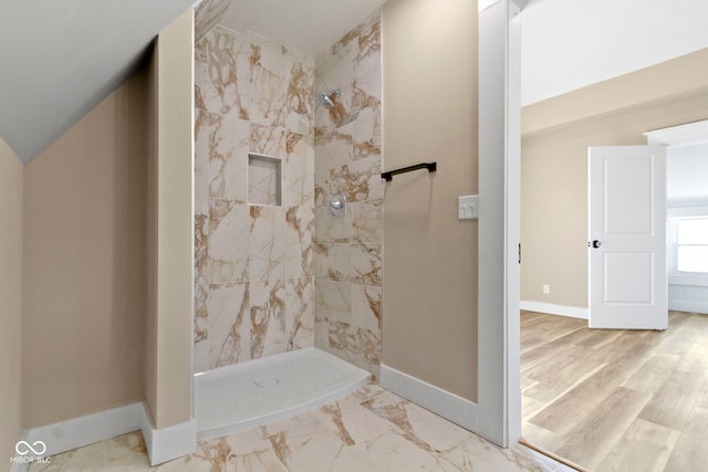 bathroom with baseboards, tiled shower, and marble finish floor