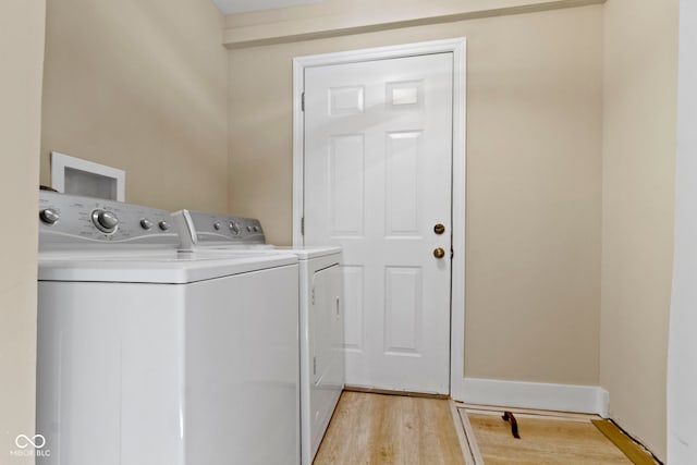 washroom featuring laundry area, light wood-style flooring, and washing machine and clothes dryer