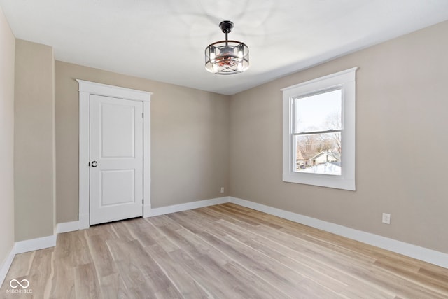 unfurnished room with baseboards and light wood-style floors