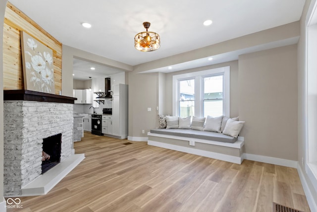 living room featuring visible vents, light wood-style flooring, recessed lighting, a fireplace, and baseboards