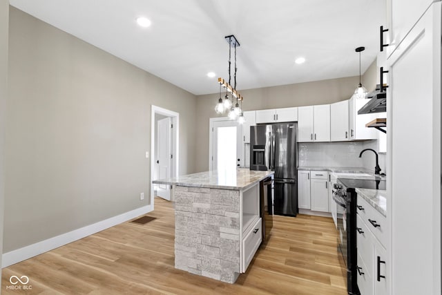 kitchen with visible vents, stainless steel fridge, white cabinetry, and black range with electric cooktop