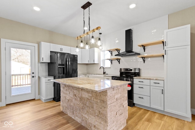 kitchen with refrigerator with ice dispenser, a sink, open shelves, stainless steel range with electric cooktop, and wall chimney exhaust hood