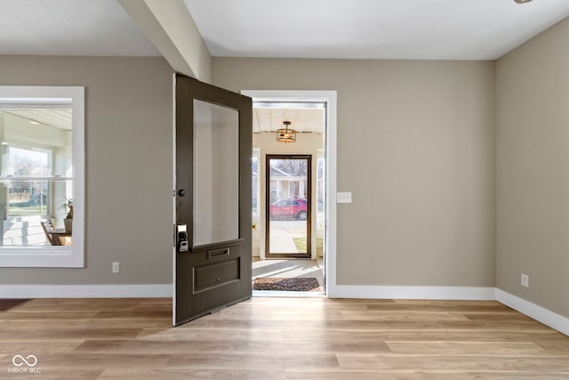 entrance foyer with plenty of natural light, visible vents, baseboards, and light wood-style floors