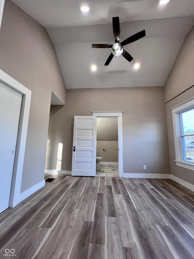 unfurnished bedroom featuring lofted ceiling, recessed lighting, wood finished floors, and baseboards