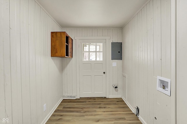 clothes washing area with hookup for a washing machine, wood finished floors, laundry area, electric panel, and baseboards