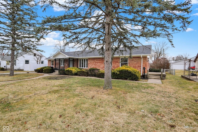 view of front of house featuring brick siding, a front yard, fence, and a shingled roof