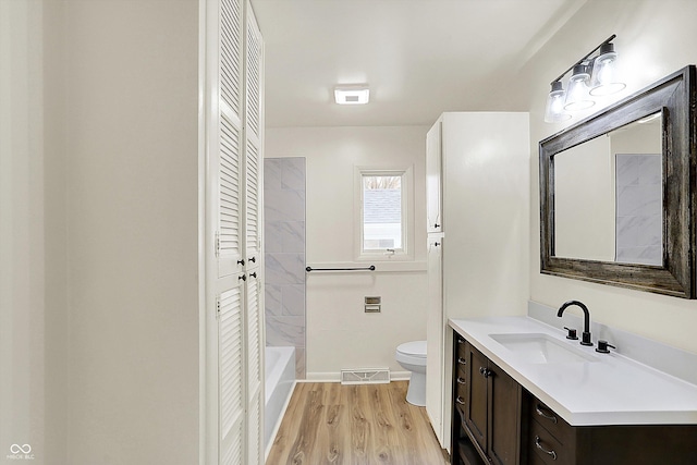 full bathroom featuring a closet, visible vents, toilet, vanity, and wood finished floors