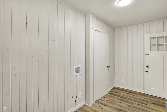 laundry area featuring washer hookup, wooden walls, wood finished floors, laundry area, and baseboards