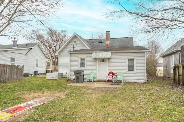 rear view of house featuring a lawn, a patio, a chimney, fence, and central air condition unit