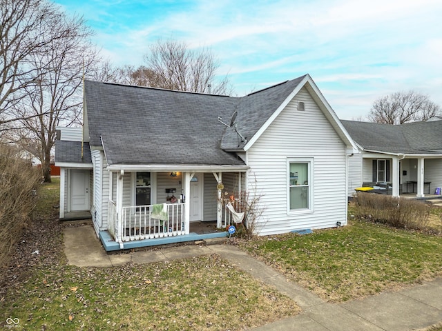 view of front of house featuring a front lawn, a porch, and roof with shingles