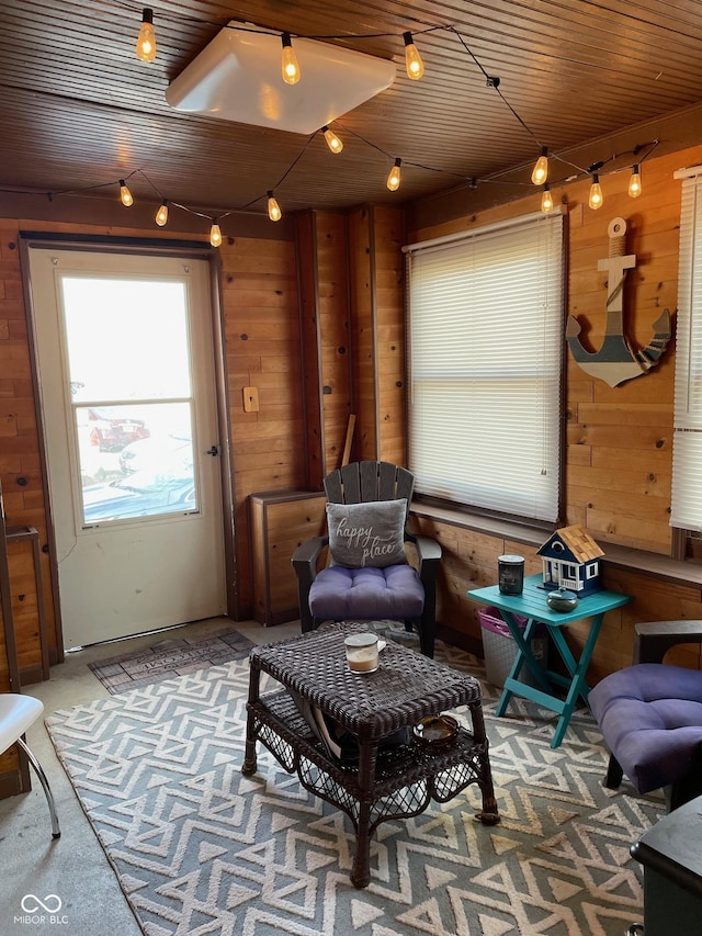 sitting room featuring carpet floors and wood walls