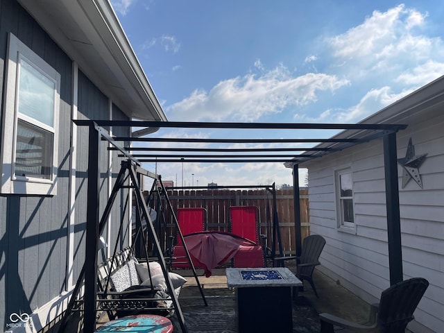 view of patio with an outdoor fire pit and fence