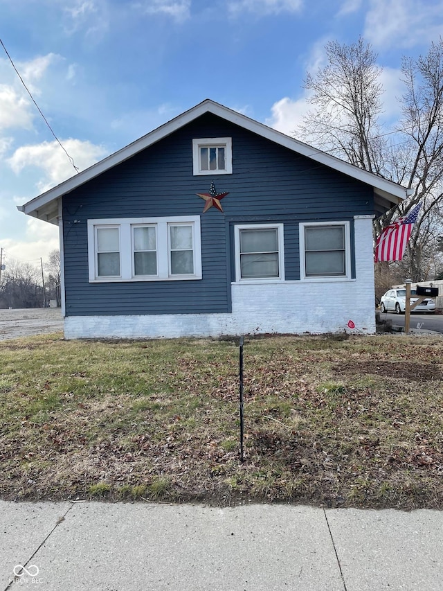 view of home's exterior with a lawn and brick siding