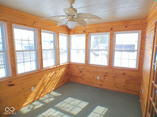 unfurnished sunroom with a healthy amount of sunlight and a ceiling fan