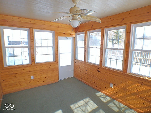 unfurnished sunroom featuring a ceiling fan