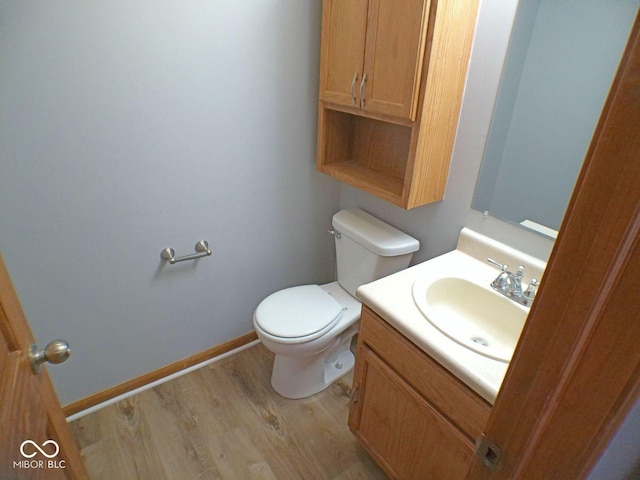 bathroom featuring vanity, wood finished floors, toilet, and baseboards