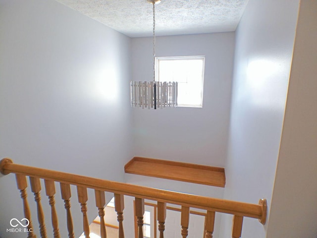 stairs featuring a textured ceiling