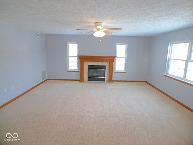 unfurnished living room featuring a textured ceiling, a fireplace, visible vents, and baseboards