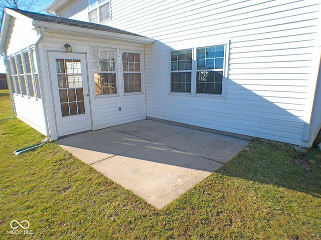 entrance to property with a lawn and a patio area