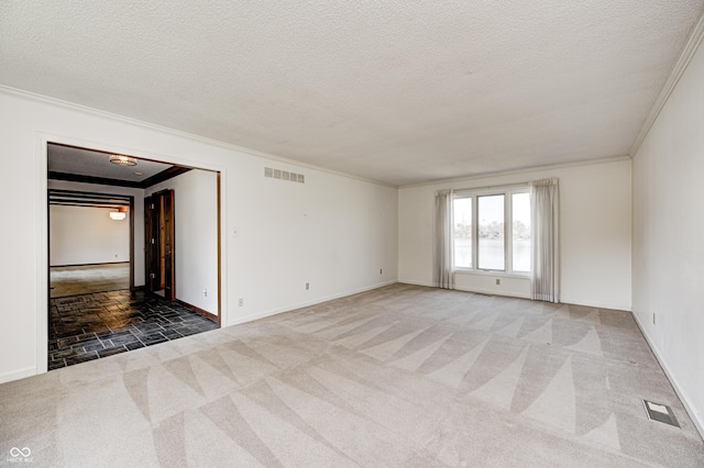 spare room with visible vents, carpet, and a textured ceiling