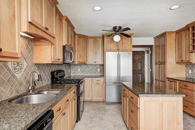 kitchen with decorative backsplash, dark stone countertops, appliances with stainless steel finishes, a ceiling fan, and a sink