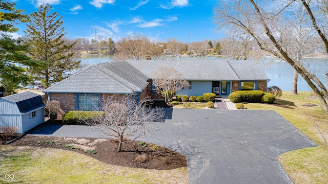 ranch-style home with a storage unit, brick siding, and an outdoor structure