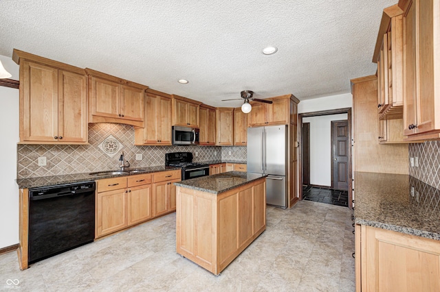 kitchen with dark stone countertops, a ceiling fan, a sink, black appliances, and a center island