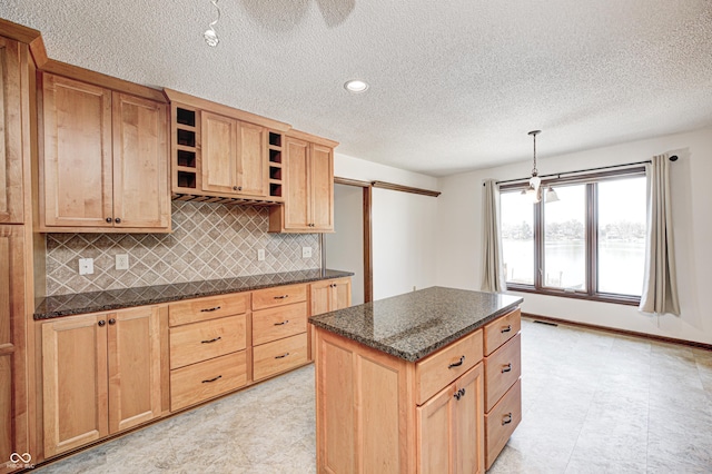 kitchen with visible vents, light brown cabinetry, open shelves, a kitchen island, and tasteful backsplash