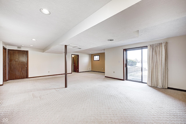 below grade area with recessed lighting, light colored carpet, baseboards, and a textured ceiling