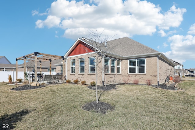 rear view of property with a pergola, fence, a yard, roof with shingles, and brick siding