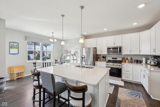 kitchen with decorative backsplash, appliances with stainless steel finishes, light countertops, and dark wood-type flooring