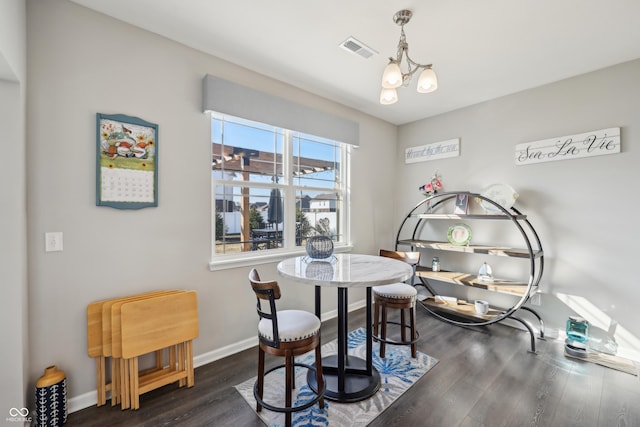 dining space with a notable chandelier, visible vents, dark wood-type flooring, and baseboards