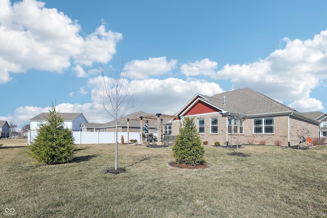 rear view of property with a yard, a residential view, brick siding, and fence