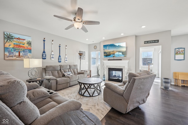 living area with wood finished floors, baseboards, recessed lighting, ceiling fan, and a glass covered fireplace