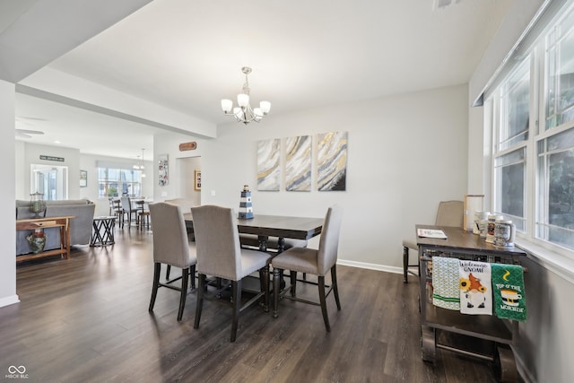 dining space with dark wood-type flooring, baseboards, and a chandelier