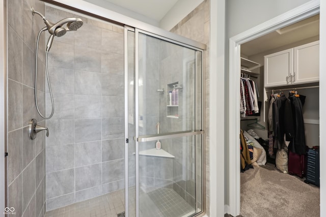 full bathroom with a spacious closet and a stall shower