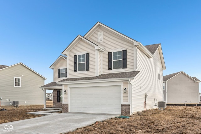 traditional home featuring central air condition unit, driveway, a garage, and brick siding