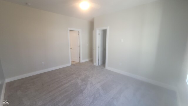 unfurnished bedroom with light carpet and baseboards