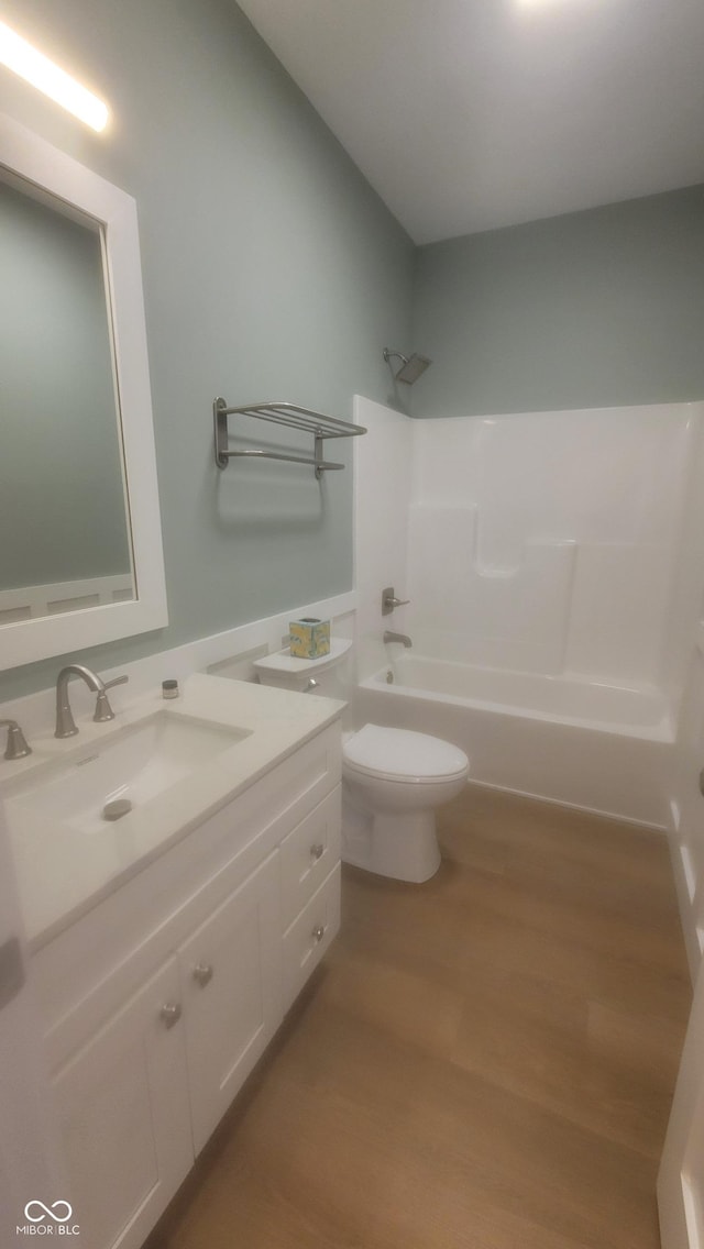 bathroom with vanity, bathing tub / shower combination, toilet, and wood finished floors